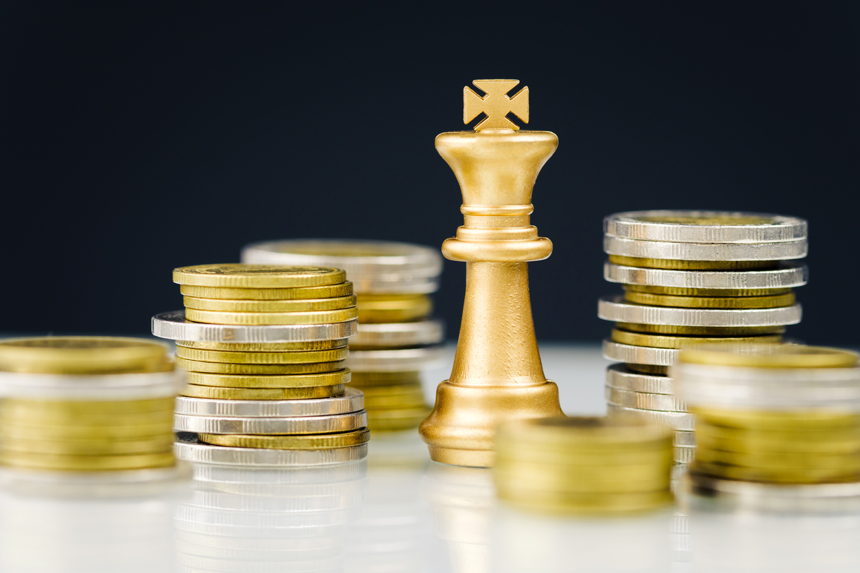 Golden king chess among the heaps of coins, financial planner, and business strategy concept